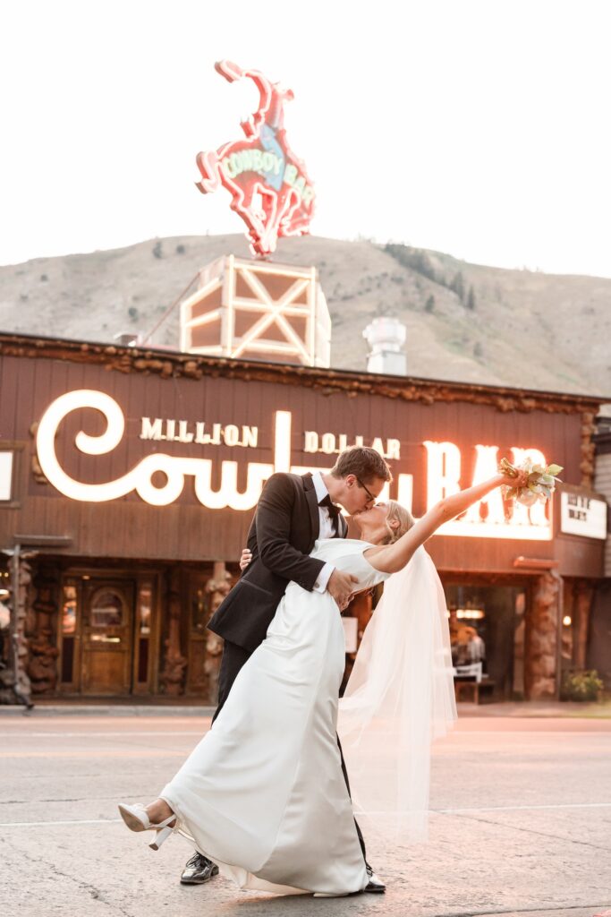 Bride and Groom just married in Jackson Hole with the iconic million dollar cowboy bar in the background