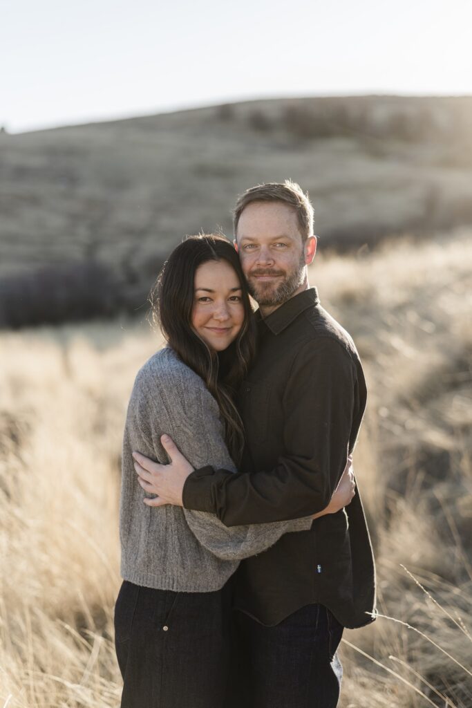 Couple smiling at the camera for their engagement photos in logan utah